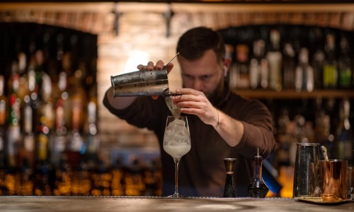 bartender crafting a custom cocktail with house infusions