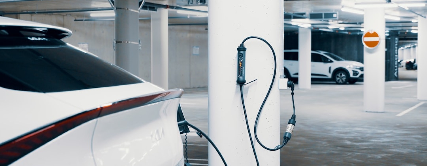 electric car charging in modern apartment garage - apartments with EV charging